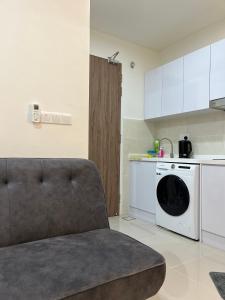 uma sala de estar com um sofá e uma máquina de lavar louça em Modern luxury Home at The Shore by Mihome em Kota Kinabalu