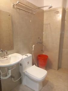 a bathroom with a toilet and a sink at Hotel First by Goyal Hoteliers in Agra