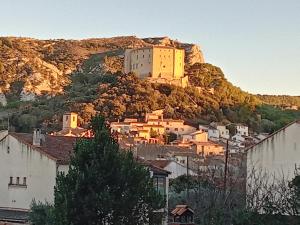 un castillo en la cima de una colina con casas en T3 campagne Aix-en-Provence, en Meyrargues