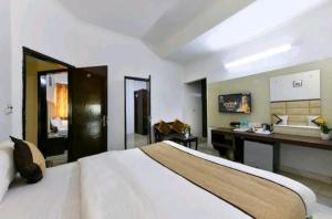 a hotel room with a bed and a desk at Hotel First by Goyal Hoteliers in Agra