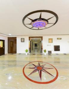 a large hall with a star on the floor and a chandelier at Hotel First by Goyal Hoteliers in Agra