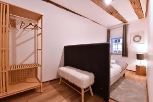 - une chambre avec un lit et un tabouret dans l'établissement Appartement My Way, à Colmar