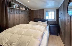 Sjusjøen的住宿－3 Bedroom Nice Home In Sjusjen，木墙和窗户的客房内的一张床位