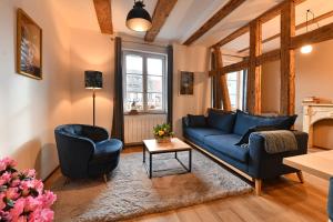 - un salon avec un canapé bleu et deux chaises dans l'établissement Appartement My Way, à Colmar