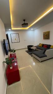 uma sala de estar com um sofá e uma televisão em Appartement 2 chambres balcon ABA em Dakar