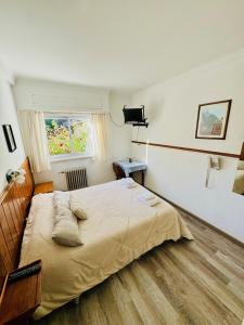 a bedroom with a large bed and a window at Hosteria El Ñire in San Carlos de Bariloche