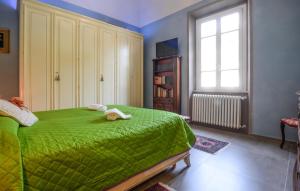 a bedroom with a green bed with a teddy bear on it at Beautiful Apartment In Volterra in Volterra