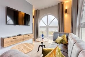 - un salon avec un canapé et une télévision dans l'établissement Inselhotel König, à Norderney