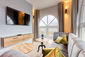 a living room with a couch and a tv at Inselhotel König in Norderney
