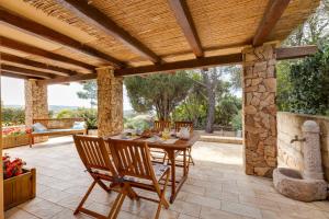 a patio with a table and chairs and a fireplace at Domu de Maria in Torre Dei Corsari
