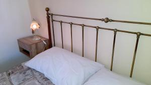 a bed with a white pillow and a lamp on a night stand at Casa Marina 50 mt dal mare in Imperia
