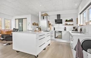 a kitchen with white countertops and a living room at Stunning Home In Roslev With Kitchen in Roslev