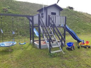a playground with a slide and toys in the grass at Letnisko Skarpa in Giżycko
