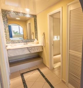 a bathroom with a large sink and a mirror at GHL Relax Hotel Costa Azul in Santa Marta