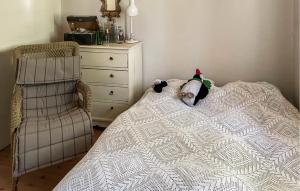 um bicho de peluche deitado numa cama ao lado de uma cómoda em Cozy Home In Frederiksvrk With Kitchen em Frederiksværk