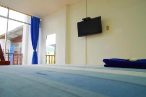 - une chambre avec un lit et une télévision murale dans l'établissement Hotel Canoa´s Wonderland, à Canoa