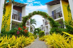 an archway in the courtyard of a building with flowers at Hotel Canoa´s Wonderland in Canoa