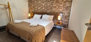 a bedroom with a large bed with two towels at Quinta do Limite - Casa do Camponês in Covilhã +20 photos