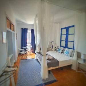 a bedroom with a bed with a blue and white curtain at Alojamentos Vista Mar-Luisa Todi in Setúbal