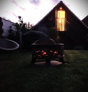 grill in a yard with a lit window w obiekcie The Cartshed, Coltishall, Norfolk w mieście Norwich