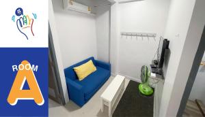 um quarto com uma cadeira azul e uma televisão em MAXi MaMa House em Bangkok