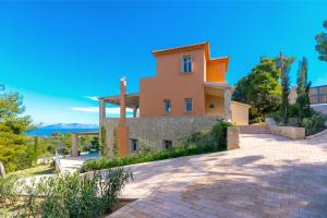 a house on a hill with a driveway at Villa Emmelia & Guesthouse Amazing View with Pool in Porto Heli