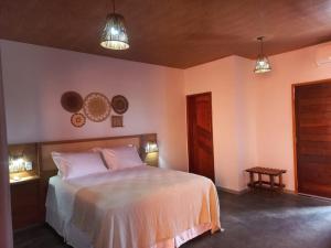 um quarto com uma cama e duas luzes pendentes em Pousada Lençóis Eco Villa em Santo Amaro