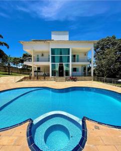 une grande piscine en face d'une maison dans l'établissement sobrado luxo, à Trindade