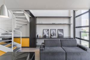 a living room with a couch and a staircase at Flat duplex com serviço de camareira e enxoval completo - ao lado do parque Ibirapuera in Sao Paulo