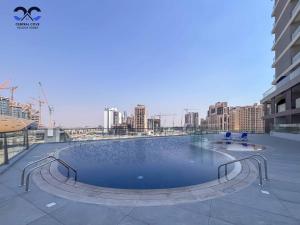 a large swimming pool on the roof of a building at Sleek & Stylish Brand New 1-BR Apt - Jaddaf Avenue in Dubai