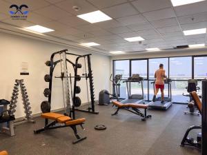 a man is standing in a gym with weights at Sleek & Stylish Brand New 1-BR Apt - Jaddaf Avenue in Dubai