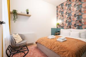 um quarto com uma cama e uma cadeira em Downtown Delight: An Artsy and Homelike Haven em Budapeste