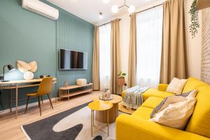 uma sala de estar com um sofá amarelo e uma secretária em Downtown Delight: An Artsy and Homelike Haven em Budapeste