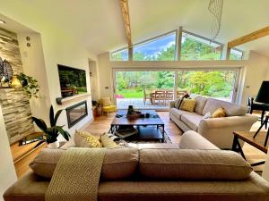 uma sala de estar com um sofá e uma grande janela em Luxury Five Bed Home - Large Garden with BBQ - New Forest and Beach Links em Saint Leonards