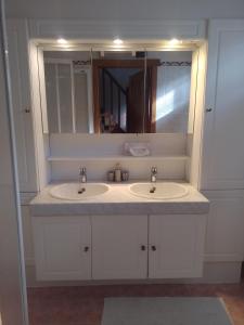 a bathroom with two sinks and a mirror at Golfbreker in De Haan
