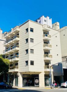 un grand bâtiment blanc avec balcon dans une rue dans l'établissement Apart Independencia, à Buenos Aires