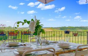 a table with chairs and a vase with flowers on it at Amazing Apartment In Montegrosso Dasti With Kitchen in Montegrosso dʼAsti