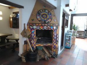 a fireplace with a clock on a wall at Ríos Voladores Hostel in Bogotá