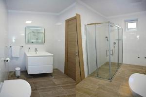 een badkamer met een douche, een toilet en een wastafel bij Apartments Petra in Bibinje