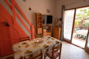a dining room with a table and a television at Charmante maison climatisée à 2km de la plage in Vias
