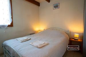 a bedroom with a bed with two towels on it at Charmante maison climatisée à 2km de la plage in Vias