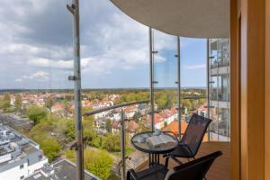 balkon z krzesłami i stołem w budynku w obiekcie Ambria Apartments Platan Tower w Świnoujściu