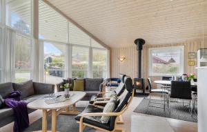 uma sala de estar com um sofá, mesas e janelas em Cozy Home In Haderslev With Kitchen em Haderslev