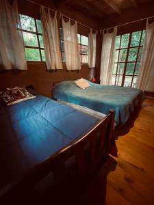 2 camas en una habitación con 2 ventanas en CABAÑA en Eco Posada Tierra Fértil, en Santa Ana