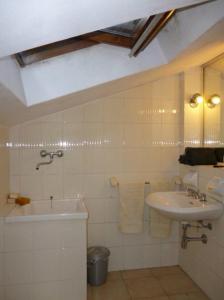 uma casa de banho branca com um lavatório e uma banheira em Mansarda luminosissima em Pesaro