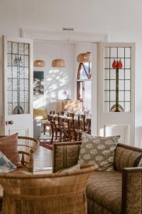 a living room with a couch and a table and chairs at Bonne Esperance, Simon's Town in Simonʼs Town