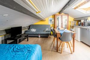 Habitación con cama, mesa y sofá en Les Gîtes du Robelier - Le nid en Bouaye