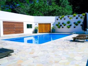 a swimming pool in a backyard with a fence and a table at VELINN Pousada Highland in Santo Antônio do Pinhal