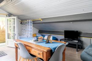 1 dormitorio con mesa con sillas y TV en Les Gîtes du Robelier - Le nid en Bouaye