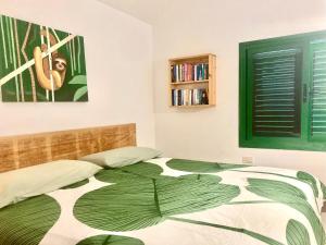a bedroom with a bed with a green and white blanket at Apartamento El Islote direct at Paradise Beach in El Cotillo
